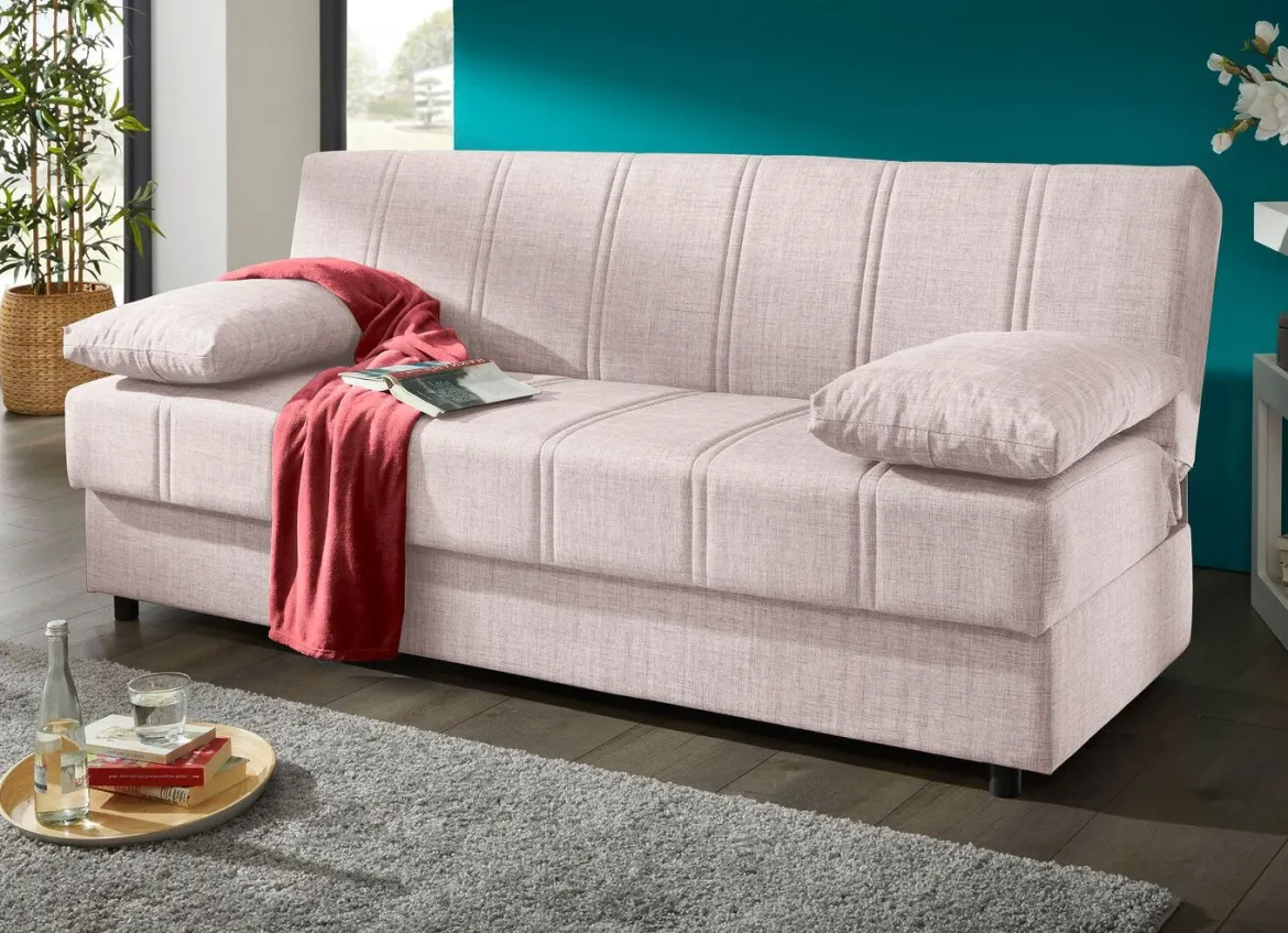 Frei im Raum aufstellbares Schlafsofa mit Dekokissen und Bettkasten
