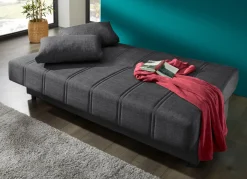 Frei im Raum aufstellbares Schlafsofa mit Dekokissen und Bettkasten